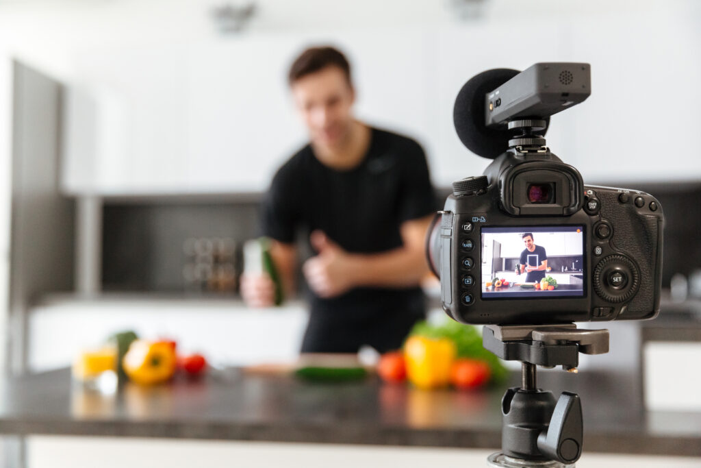 Close Up Of A Video Camera Filming Young Smiling Male Blogger - PAVON | Contabilidade em São Paulo