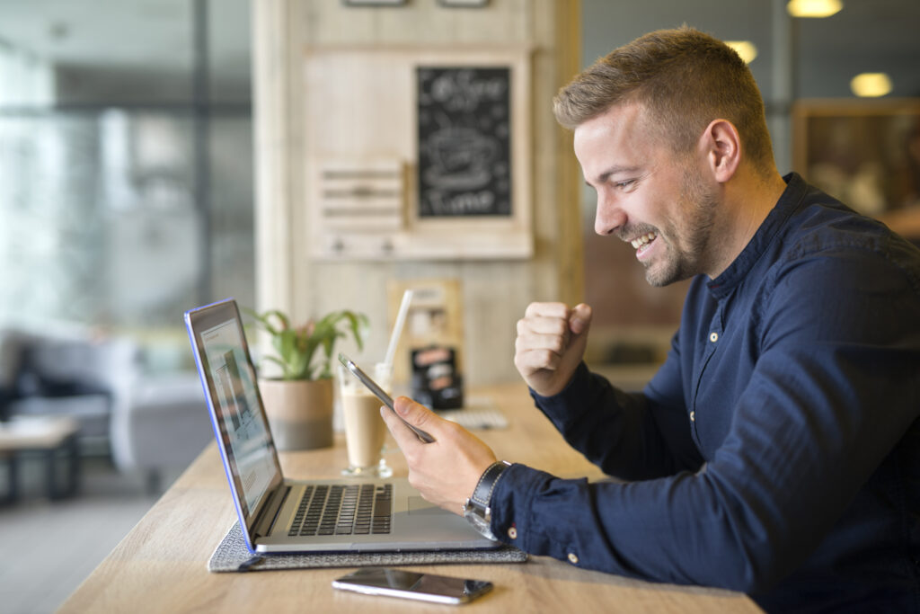 Happy Freelancer With Tablet And Laptop Computer In Coffee Shop. - PAVON | Contabilidade em São Paulo