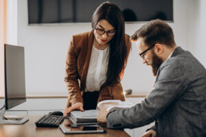 Two Business Partners Working Together In Office On Computer - PAVON | Contabilidade em São Paulo