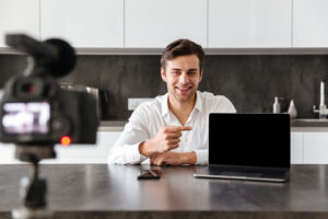 Smiling Young Man Filming His Video Blog Episode - PAVON | Contabilidade em São Paulo