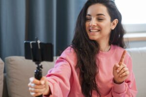 Young Blogger Holding Her Smartphone Finger Up - PAVON | Contabilidade em São Paulo