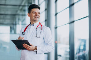 Young Handsome Physician In A Medical Robe With Stethoscope - PAVON | Contabilidade em São Paulo