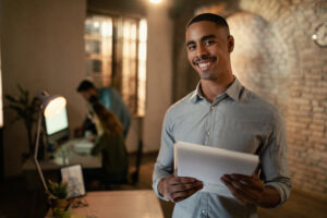 Portrait Of Happy African American Entrepreneur Working At Night - PAVON | Contabilidade em São Paulo