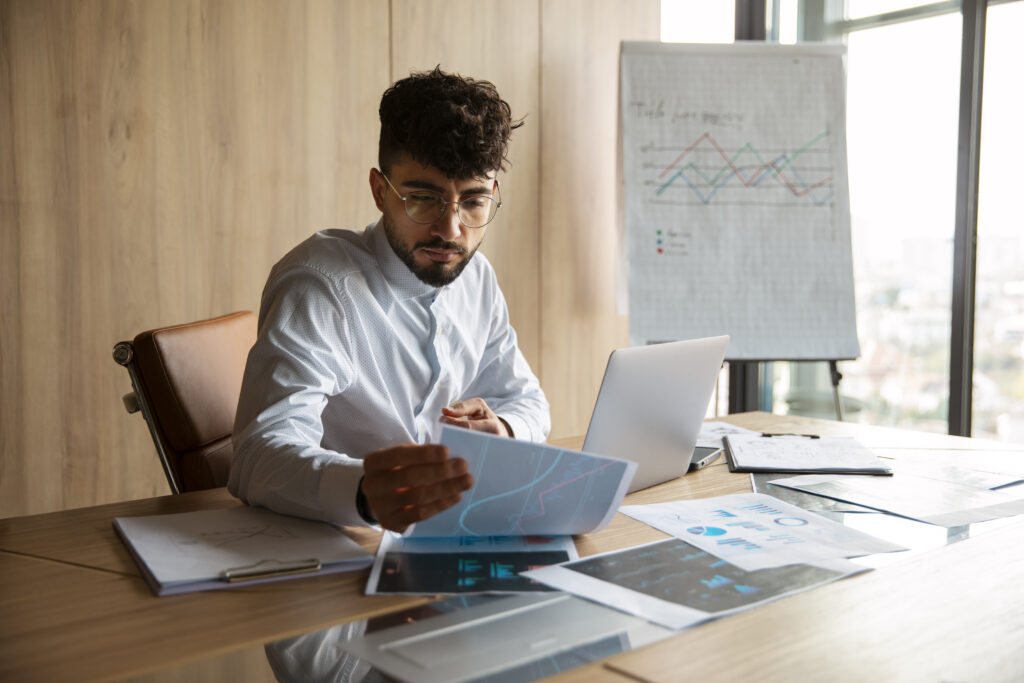 Office Worker Using Finance Graphs - PAVON | Contabilidade em São Paulo