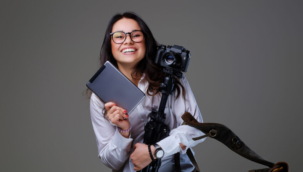 Female Photographer Holds Tripod And Tablet Pc. - PAVON | Contabilidade em São Paulo