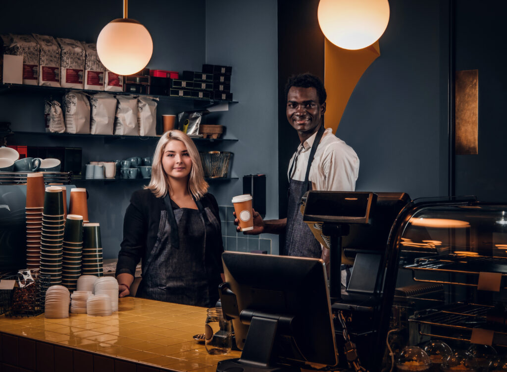 Couple Barista Standing Behind A Counter In The Coffee Shop. - PAVON | Contabilidade em São Paulo