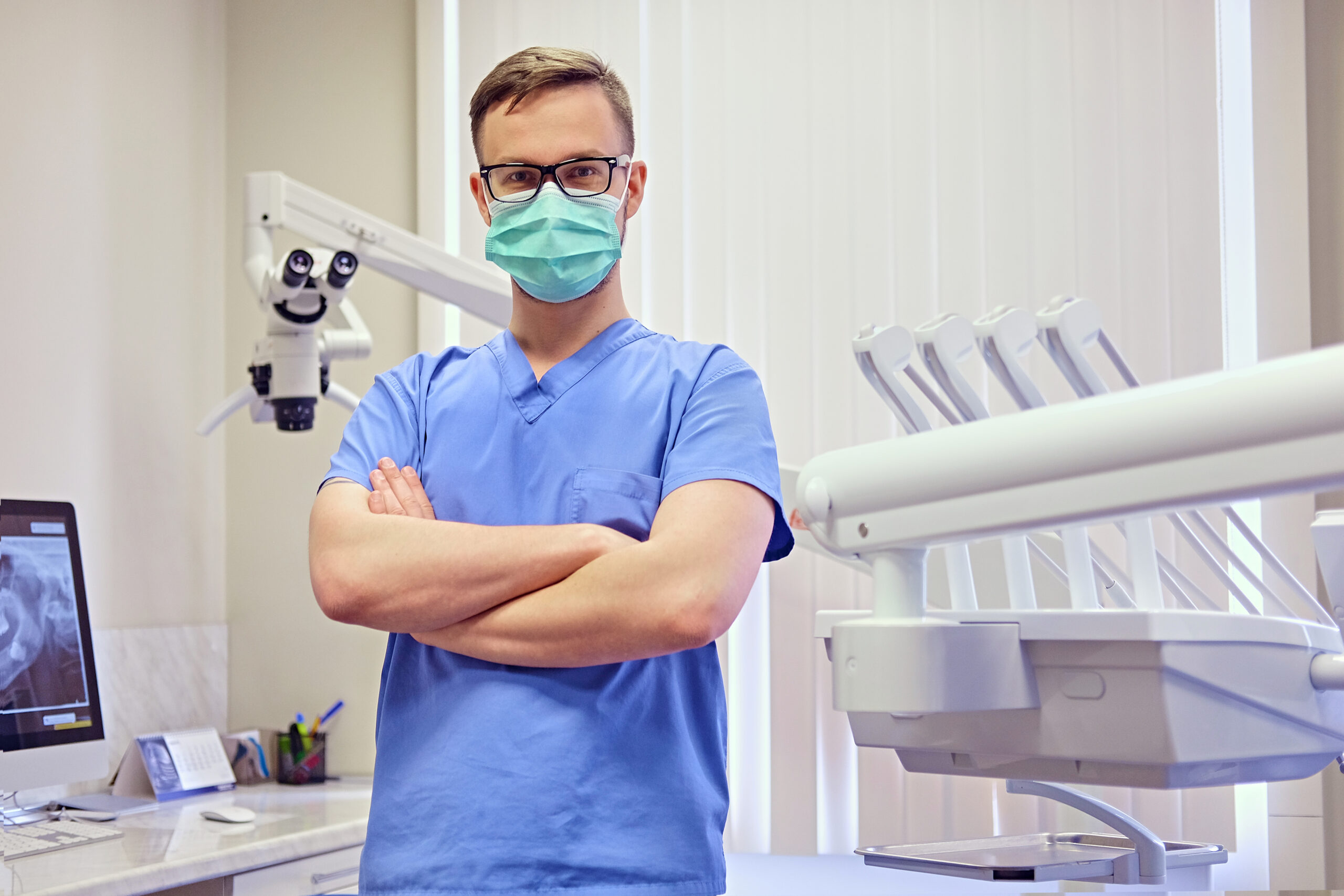 Dentist In A Room With Medical Equipment On Background. - PAVON | Contabilidade em São Paulo
