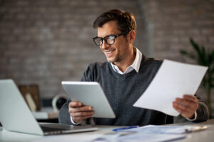 Happy Businessman Multi Tasking While Working On New Project In The Office. - PAVON | Contabilidade em São Paulo