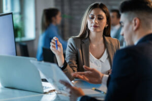Young Businesswoman And Her Coworker Analyzing Business Reports In The Office. - PAVON | Contabilidade em São Paulo