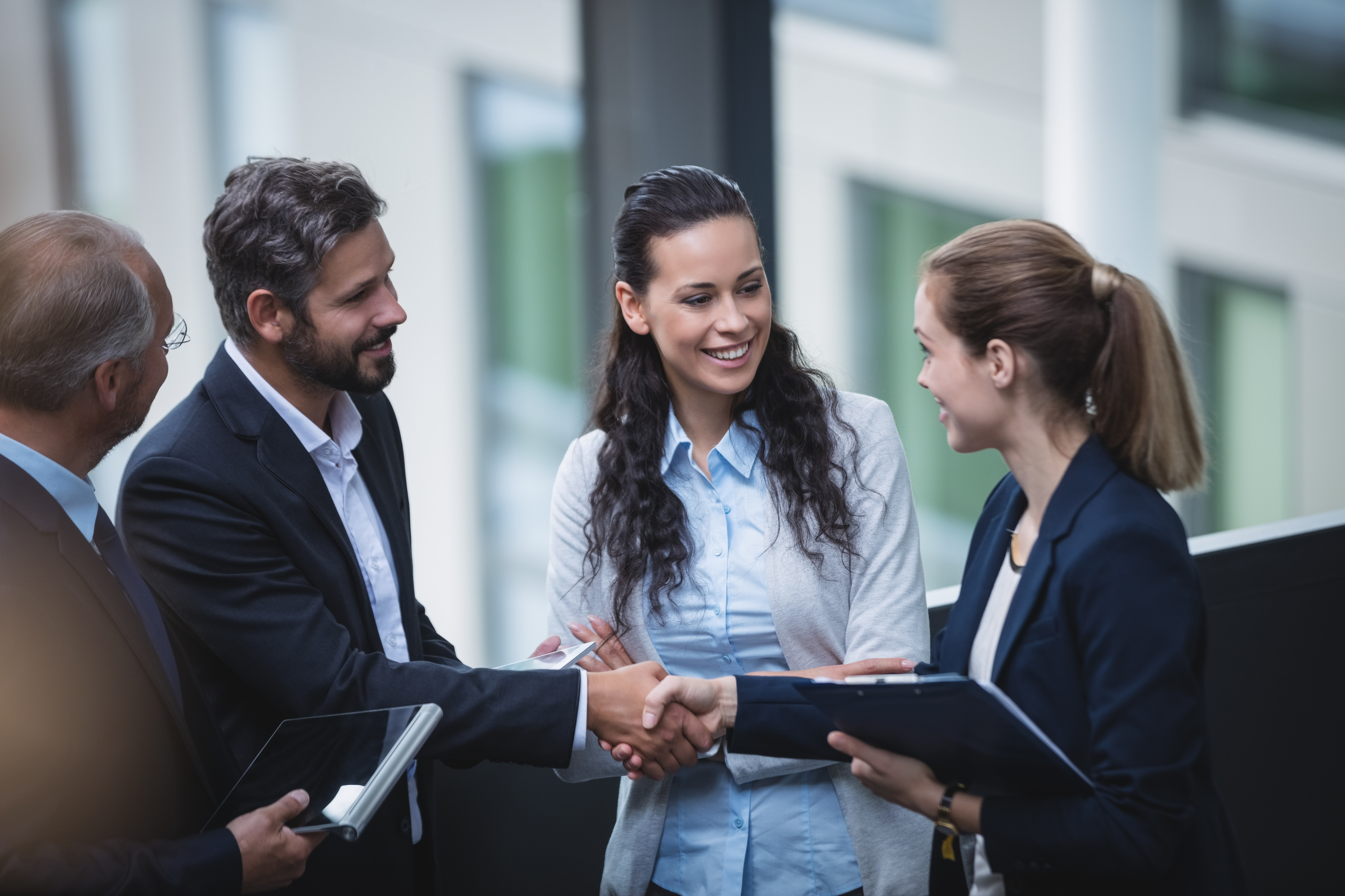 Group Of Businesspeople Having A Discussion Near Staircase In Office - PAVON | Contabilidade em São Paulo