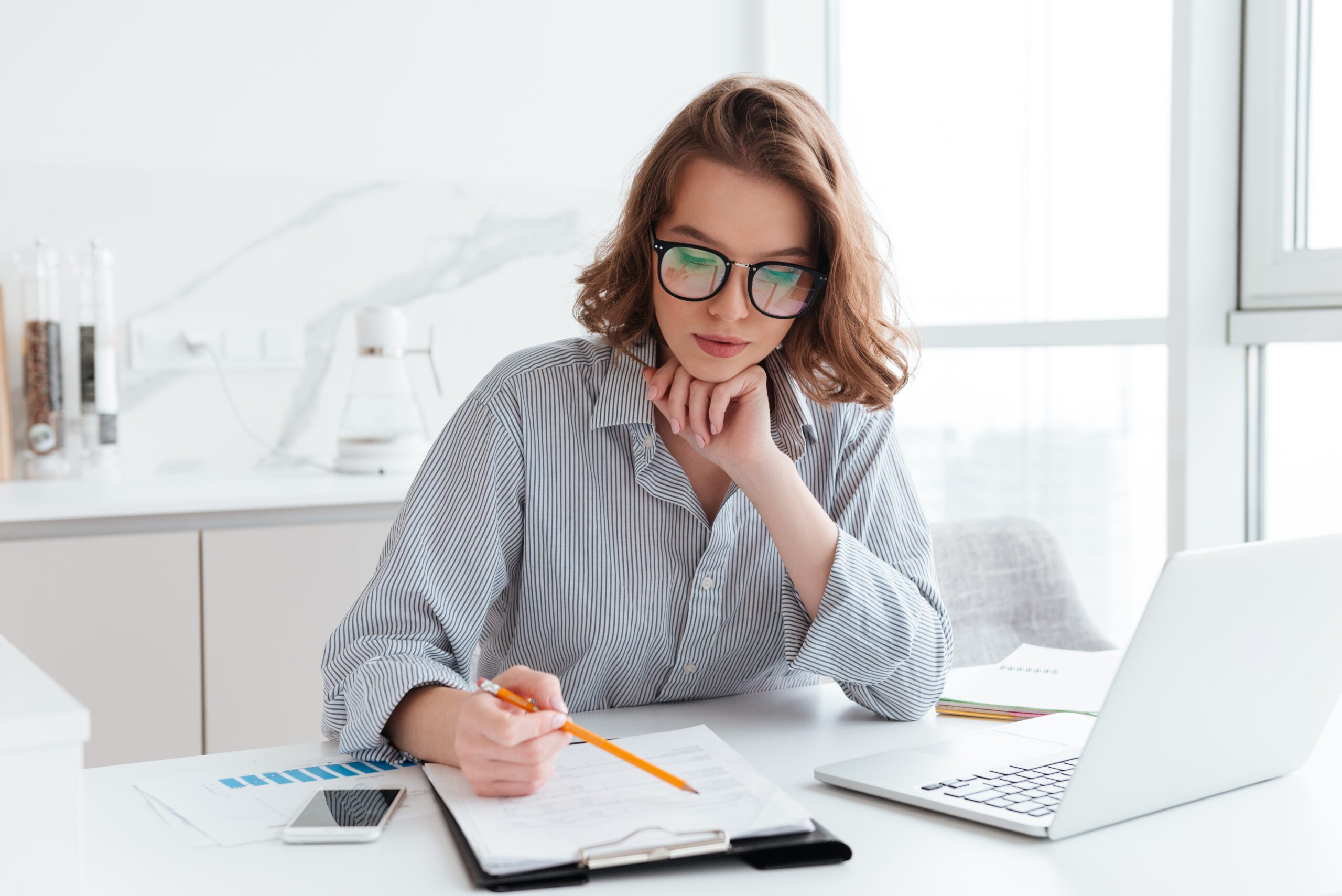 Young Concentrated Businesswoman In Glasses And Striped Shirt Wo - PAVON | Contabilidade em São Paulo