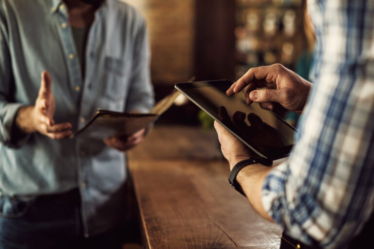 Close Up Of Waiter Taking Order On Digital Tablet In A Cafe. - PAVON | Contabilidade em São Paulo