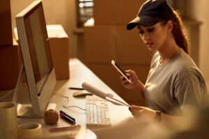 Female Courier Going Through Paperwork While Working In The Offi - PAVON | Contabilidade em São Paulo