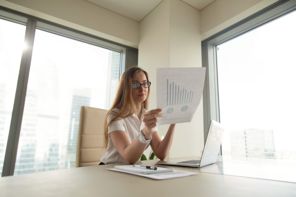 Businesswoman Reading Document With Graphs - PAVON | Contabilidade em São Paulo