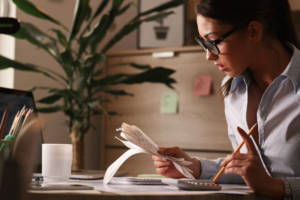 Young Businesswoman Going Through Finances And Analyzing Bills In The Office. - PAVON | Contabilidade em São Paulo