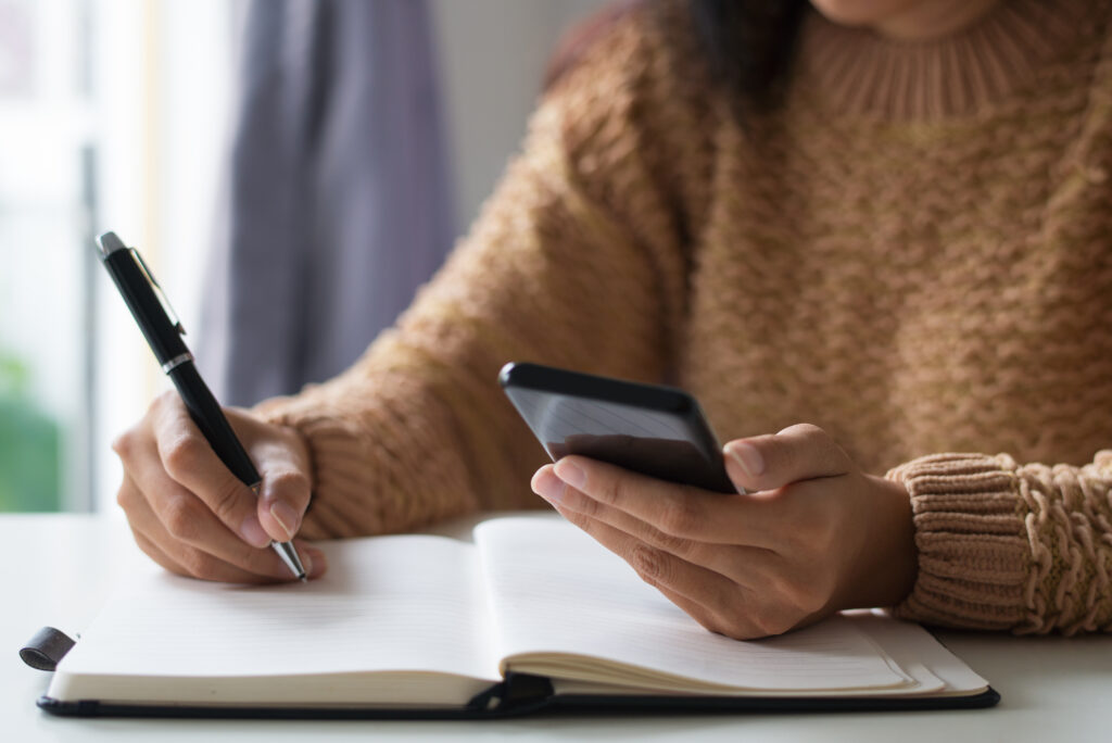 Close Up Of Businesswoman Planning Timetable Using Smartphone - PAVON | Contabilidade em São Paulo