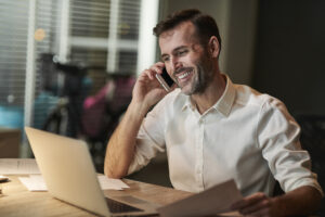 Smiling Businessman Talking By Mobile Phone - PAVON | Contabilidade em São Paulo